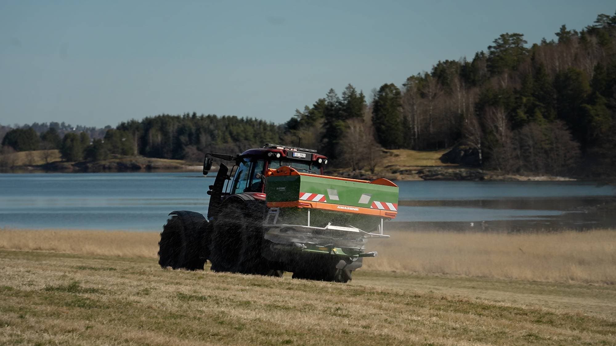 En traktor gjødsler jorde ved Oslofjorden 