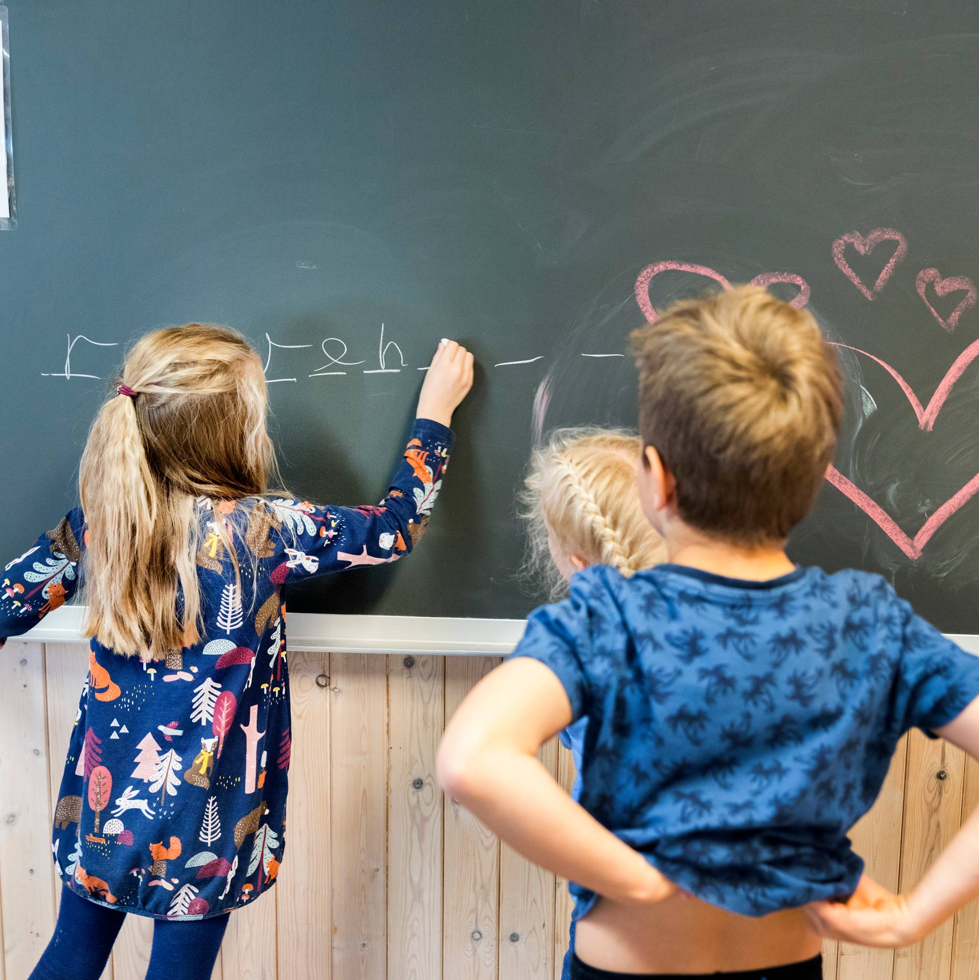 Elever som tegner på tavle i klassesituasjon på barneskole.
