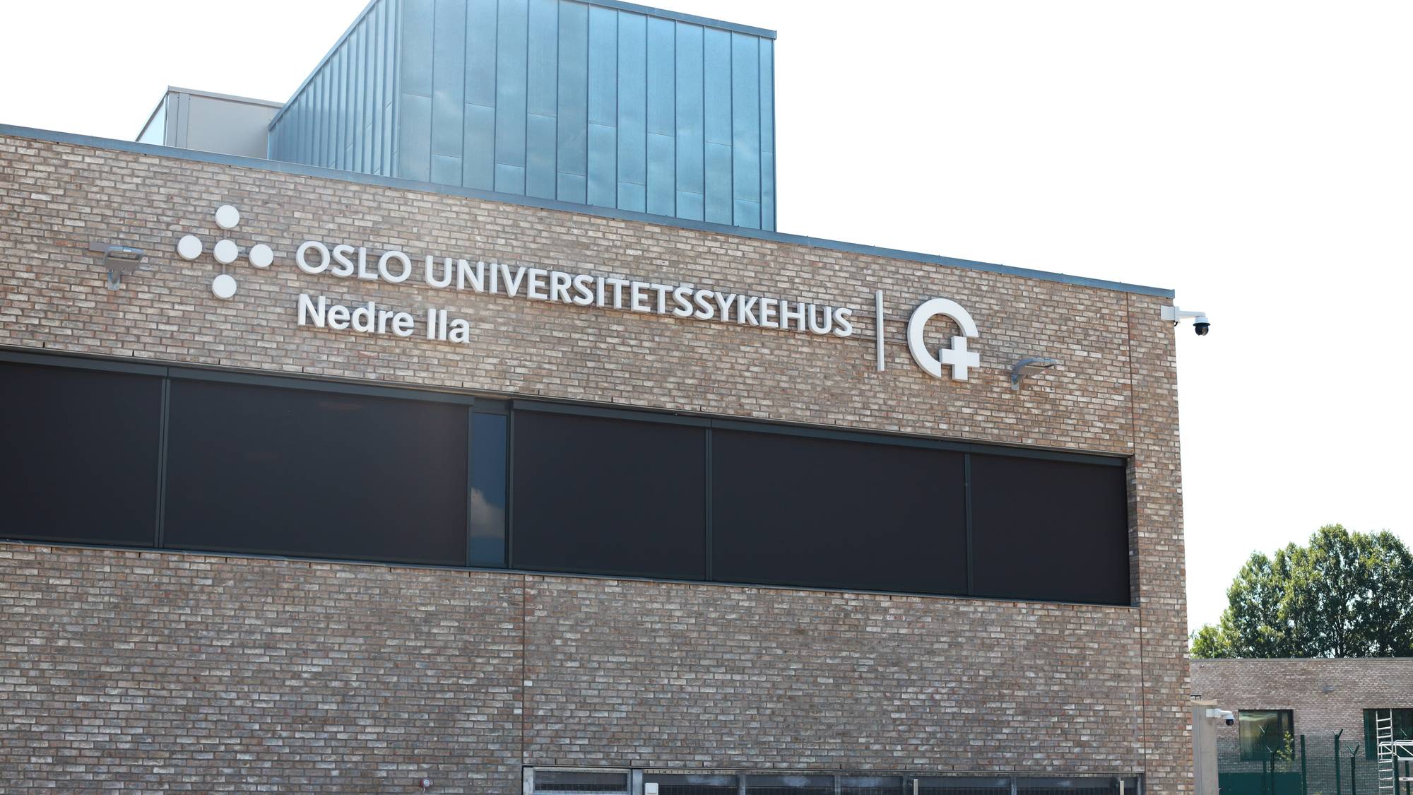 På bildet ser man en murstensbygning. Med store bokstaver står det skrevet OSLO UNIVERSITETSSYKEHUS og under står det Nedre Ila.