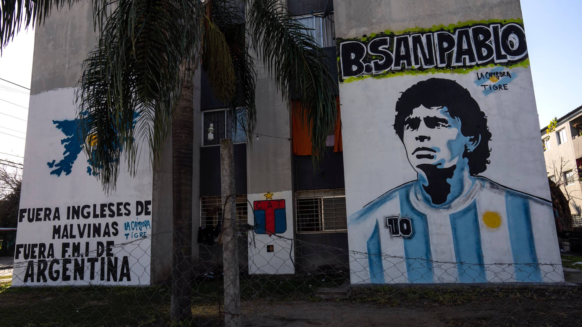 Veggmaleri av Diego Maradona på en boligblokk med politiske slagord om Falklandsøyene. (Bildebeskrivelsen er laget av en KI-tjeneste)