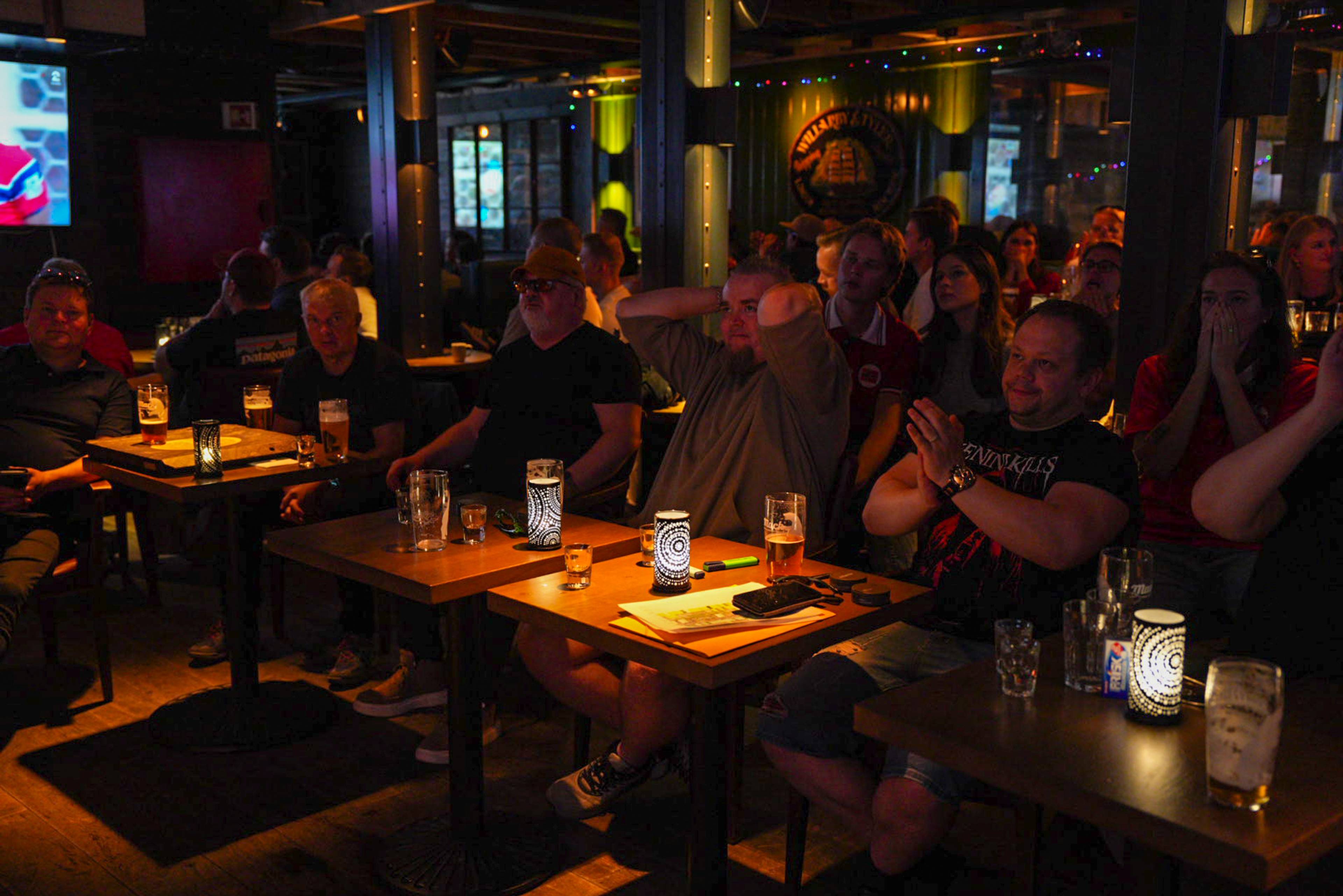 menn sitter på bar, smiler og klapper