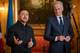 Torstein Georg Bøe / NRK Ukrainas president Volodymyr Zelenskyj og Norges statsminister Jonas Gahr Støre taler ved et arrangement. Zelenskyj taler med hendene i været foran et ukrainsk flagg. Støre står ved siden av ham i dress og slips. De står foran mikrofoner. (Bildebeskrivelsen er laget av en KI-tjeneste)