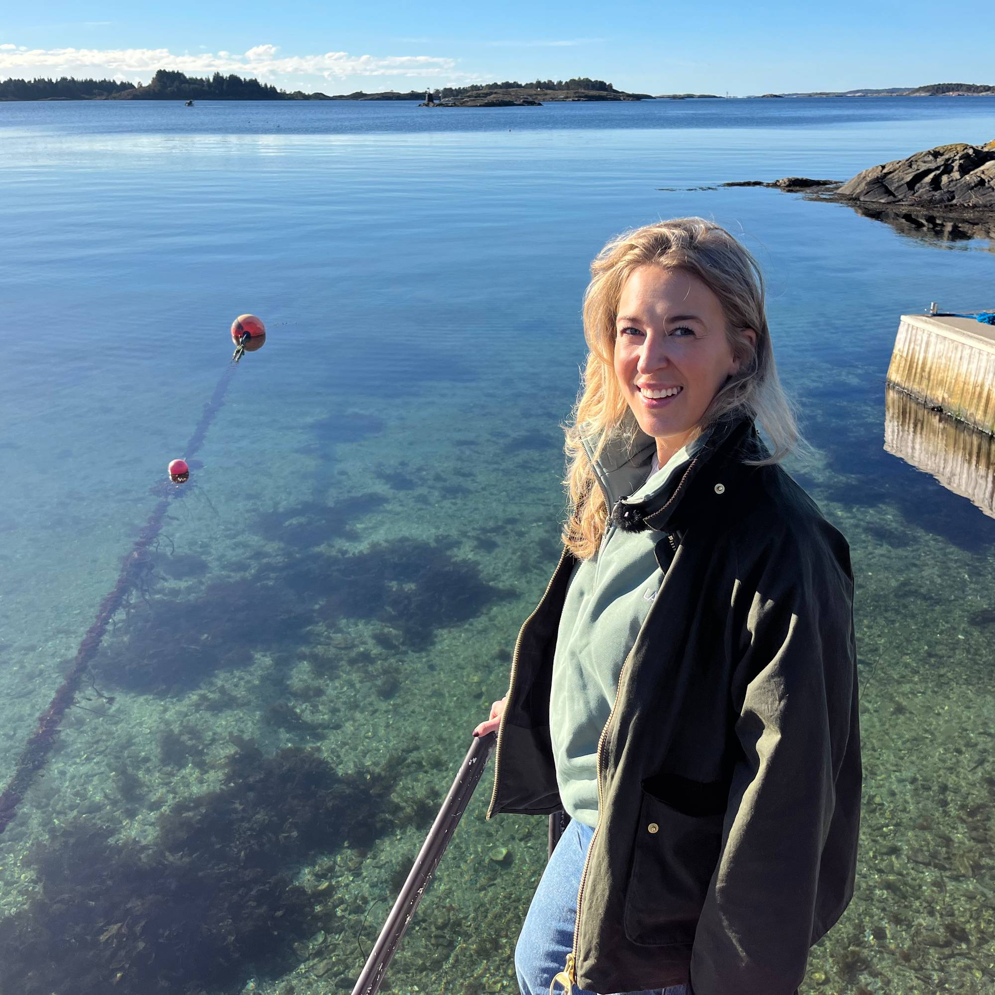 En kvinne står ved sjøen