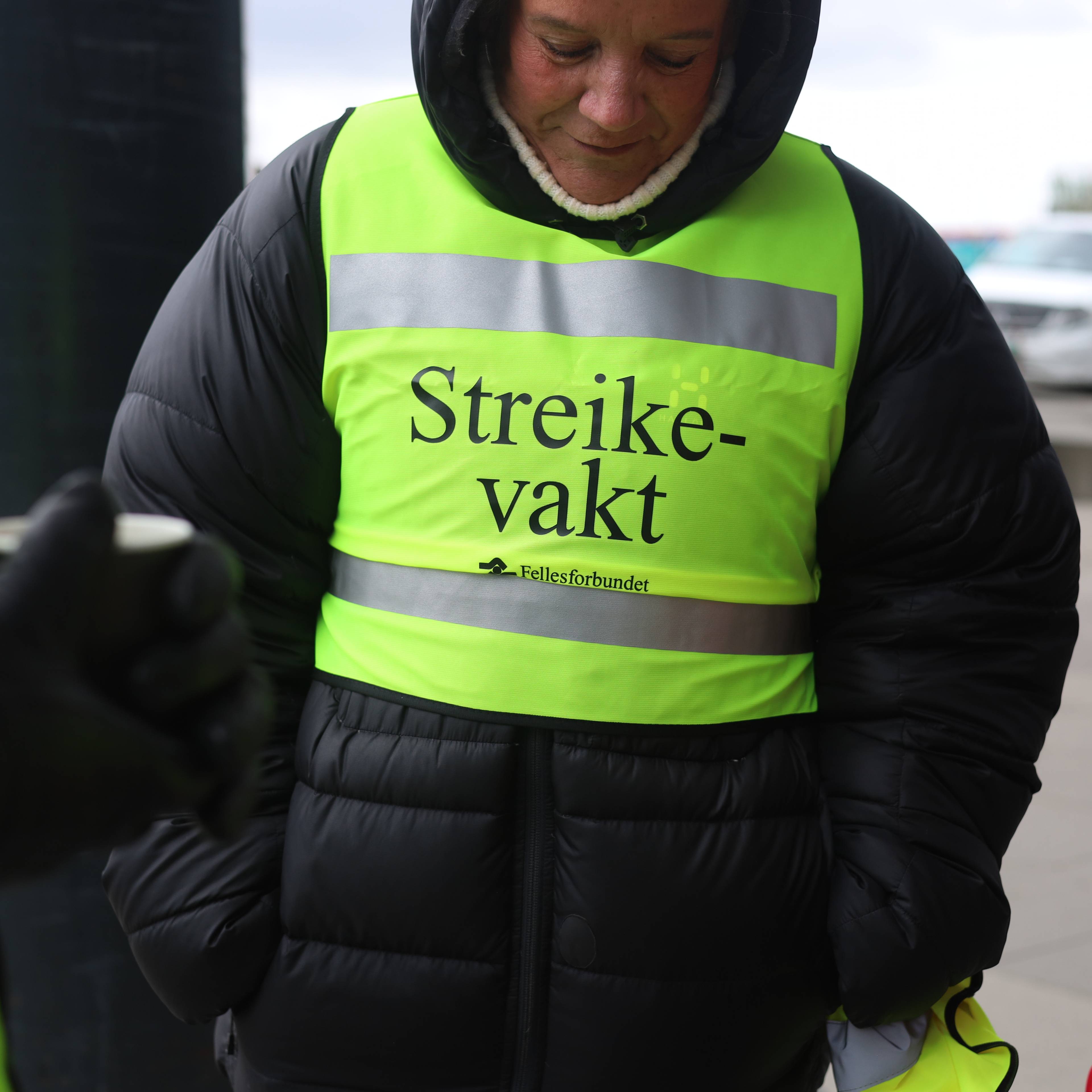 Ei dame har på en refleks hvor det står "streikevakt".