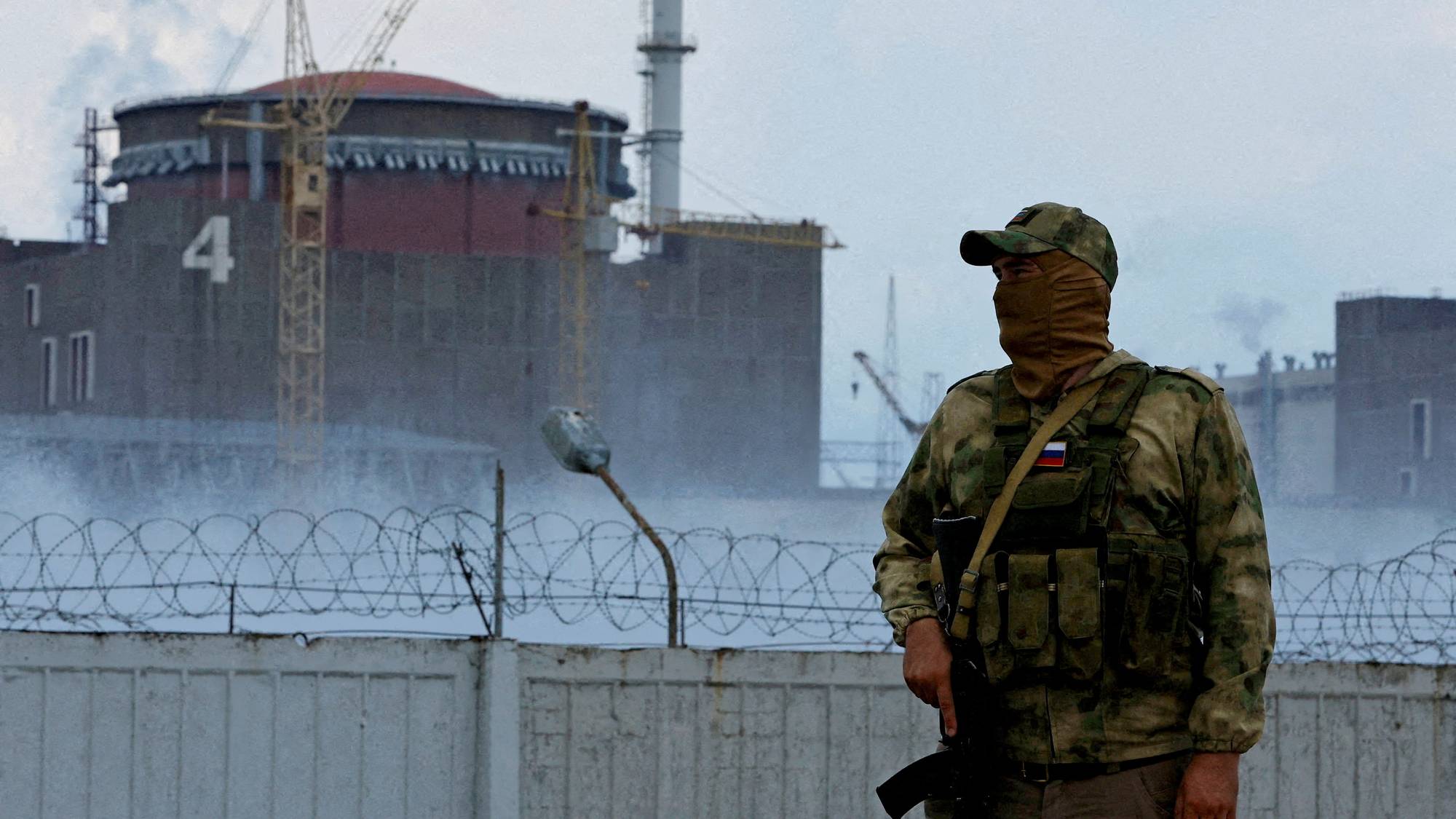 Ein russisk soldat held vakt utanfor atomkraftverket i Zaporizjzja. Bilete er frå august.