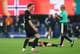 CAEAN COUTO / REUTERS,NTB Fotballspiller jubler mens dommeren ser på. En spiller ligger på bakken. Bakgrunnen viser et norsk flagg. (Bildebeskrivelsen er laget av en KI-tjeneste)