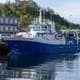 Jonas Been Henriksen / NTB Et blått og hvitt forskningsfartøy ligger ved kai i en havn. Bak fartøyet ligger en lang rekke med containere stablet i høyden. I bakgrunnen er en borg eller festning synlig på en grønnkledd ås. (Bildebeskrivelsen er laget av en KI-tjeneste)