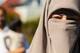 Lars Thomas Nordby / NRK Et nærbilde av en person som bærer niqab, med et øye synlig. Bildet er tatt utendørs med uskarpe personer i bakgrunnen. Detaljer om hendelse eller kontekst er uklare. (Bildebeskrivelsen er laget av en KI-tjeneste)