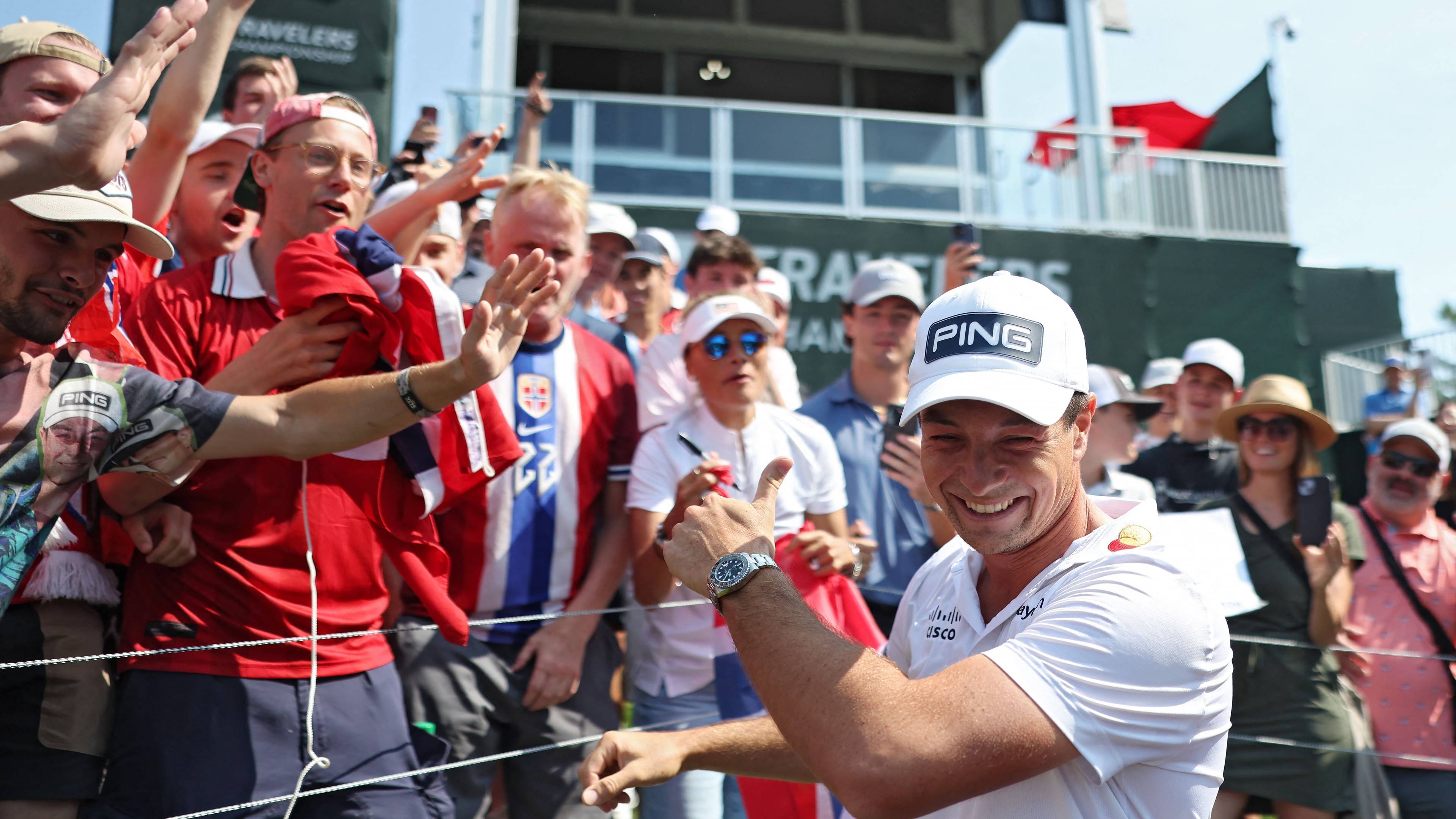 Golfspiller smiler og gir tommel opp til tilskuere under en golfturnering. (Bildebeskrivelsen er laget av en KI-tjeneste)