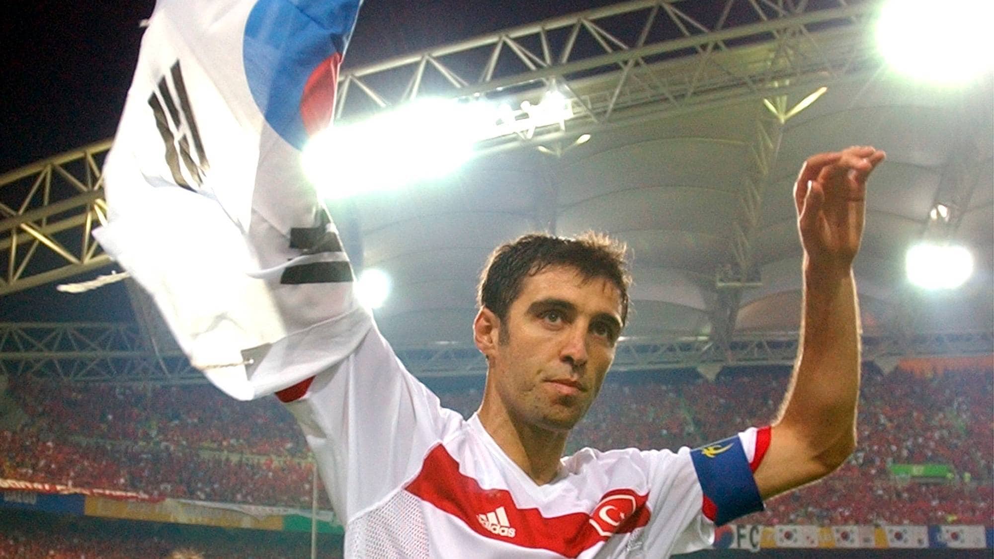 FILE - In this Saturday, June 29, 2002, file photo, Turkey's Hakan Sukur holds a South Korean flag at the end of the 2002 World Cup third place playoff soccer match between South Korea and Turkey, at the Daegu World Cup stadium, in Daegu, South Korea. Turkey's state-run news agency reports Friday, Aug. 12, 2016, authorities have issued an arrest warrant for former soccer star and legislator Hakan Sukur over his alleged links to a U.S.-based Muslim cleric, accused by Turkey of masterminding last month's failed coup. (AP Photo/Vincent Yu, FILE)