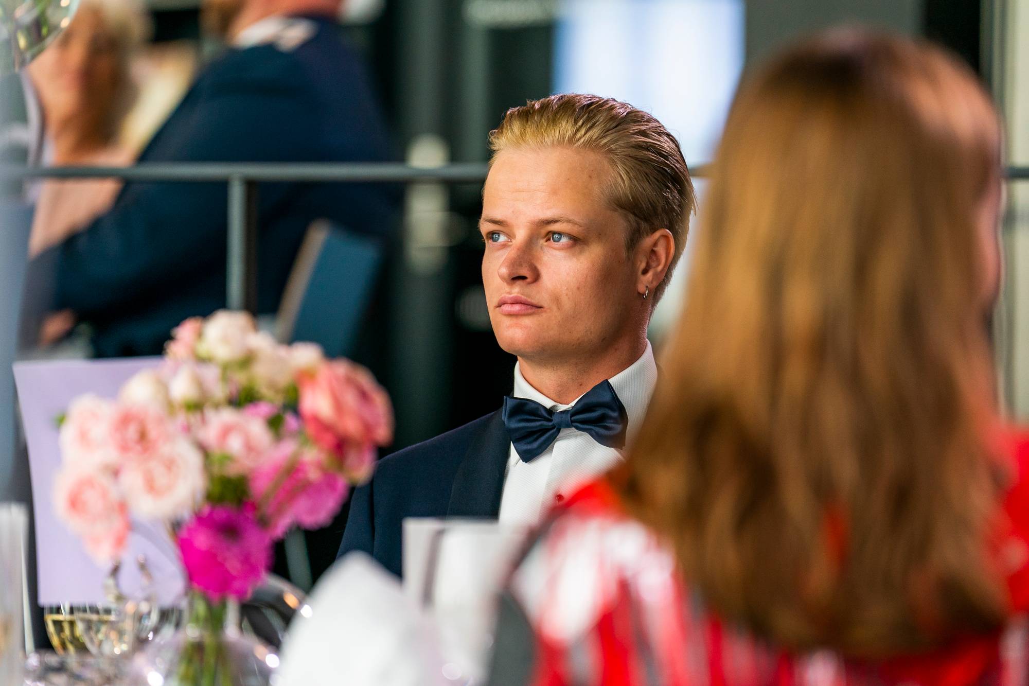 Marius Borg Høiby i smoking som sitter ved et bord med blomster