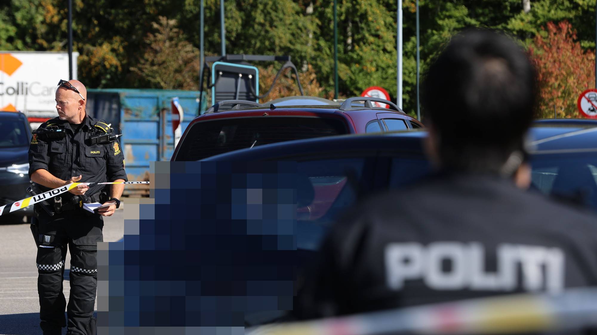 Politibetjenter, sperrebånd rundt en bil på en parkeringsplass.