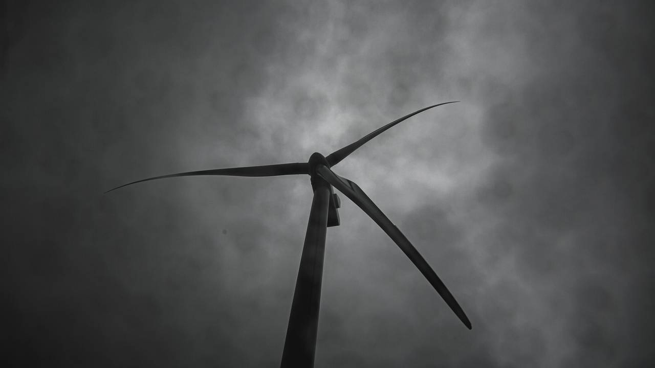Et halvtotalt utsnitt av en vindturbin i Roan vindkraftanlegg. Man ser en grå himmel med mørke skyer i bakgrunnen.