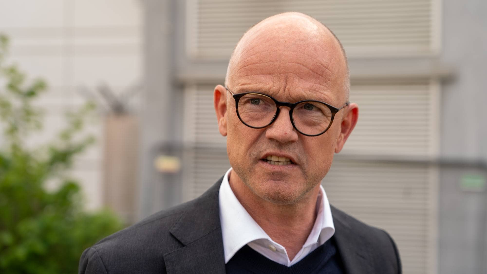 En penkledd mann med briller.