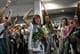 写真: ARIS MESSINIS / AFP / NTB 空港で花で出迎えられたグレタ・トゥーンベリさんは拳を握る。