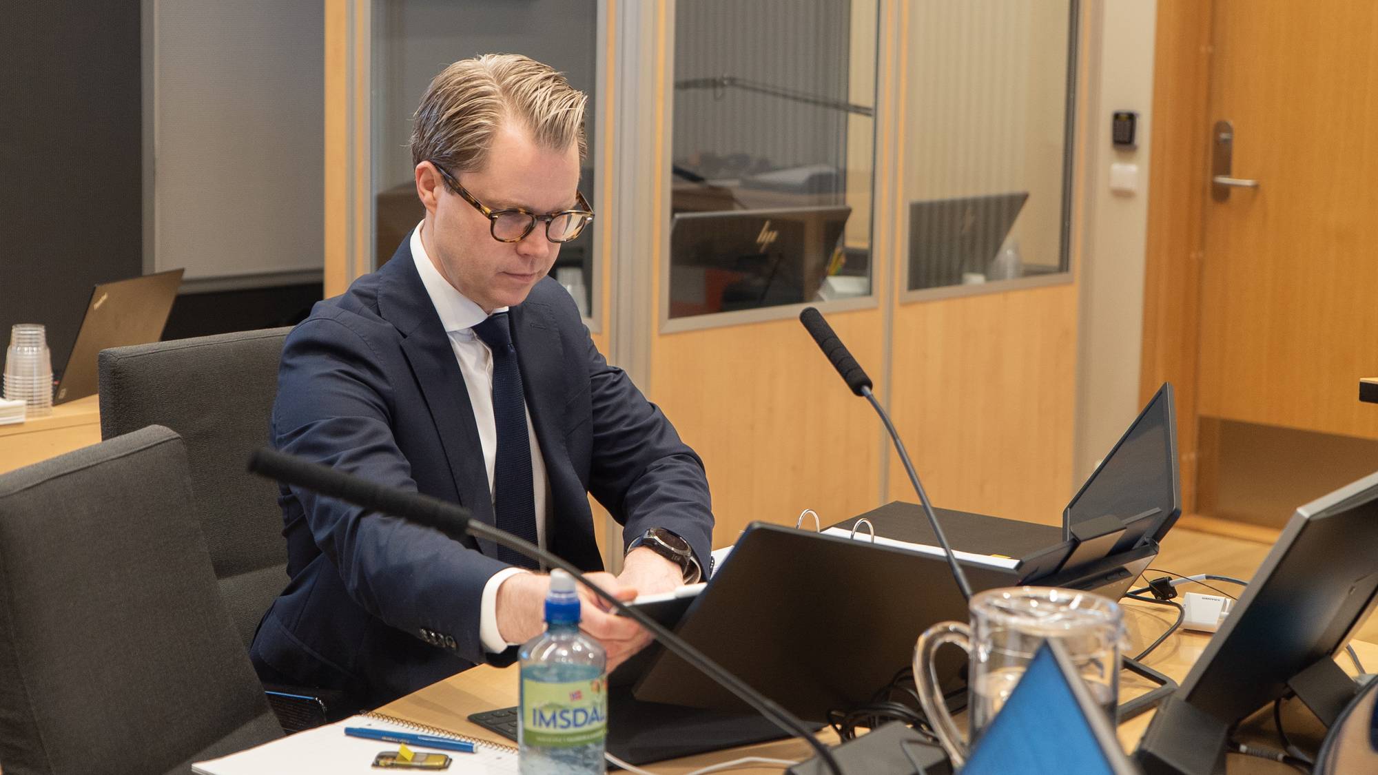 En advokat sitter i en rettssal og gjør klar pc og papir.