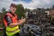 Christian Ziegler Remme / NRK Innsatsleder Kenneth Wangen fra Nedre Romerike brann- og redningsvesen står i kurven på en lift med en utbrent terrasseblokk på Kurlandsåsen i bakgrunnen.