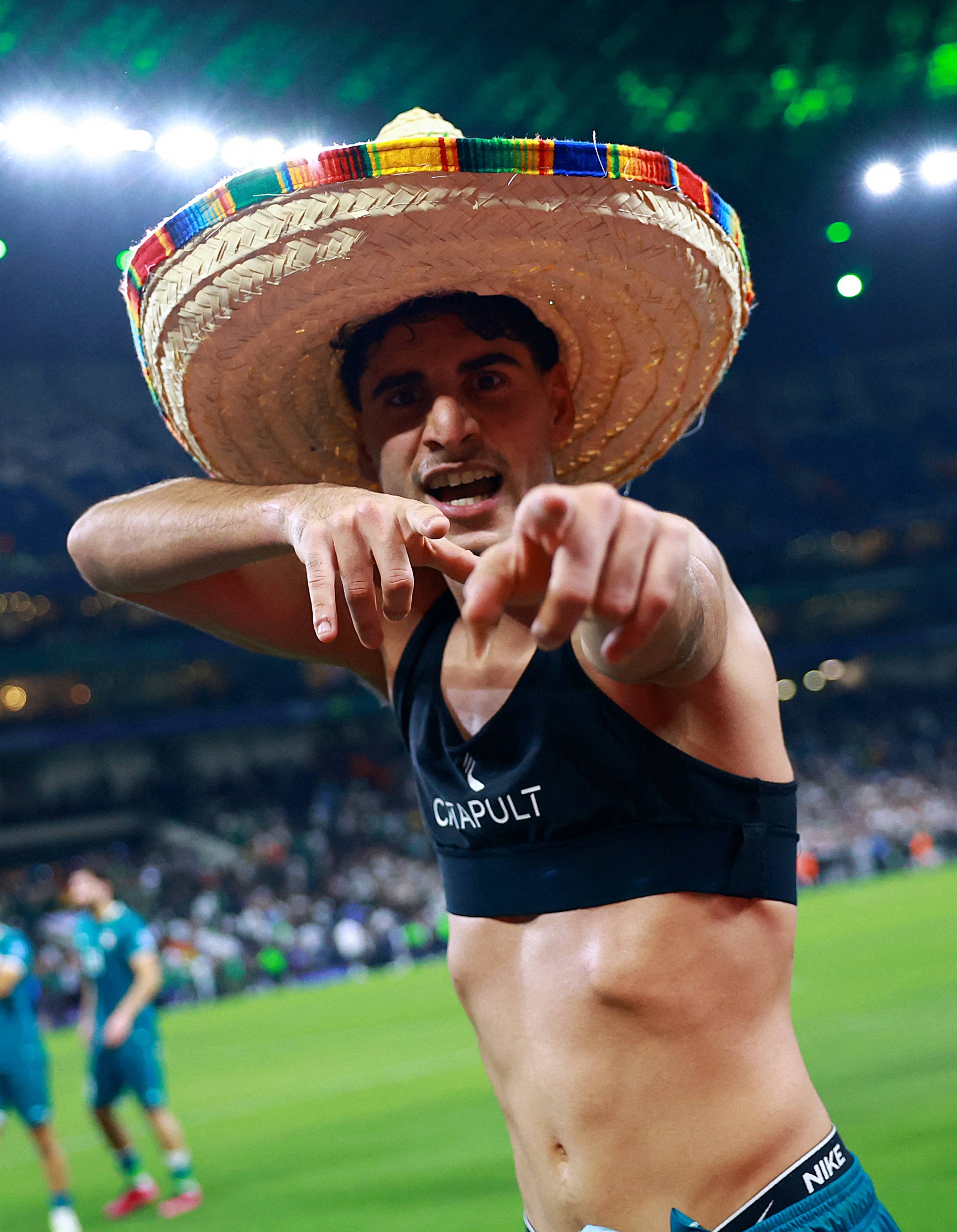 En fotballspiller med sombrero peker mot kamera.Spilleren har på seg en Cropult sports-BH og Nike-shorts.Bakgrunnen viser et stadion med tilskuere.Spilleren ser ut til å feire. (Bildebeskrivelsen er laget av en KI-tjeneste)