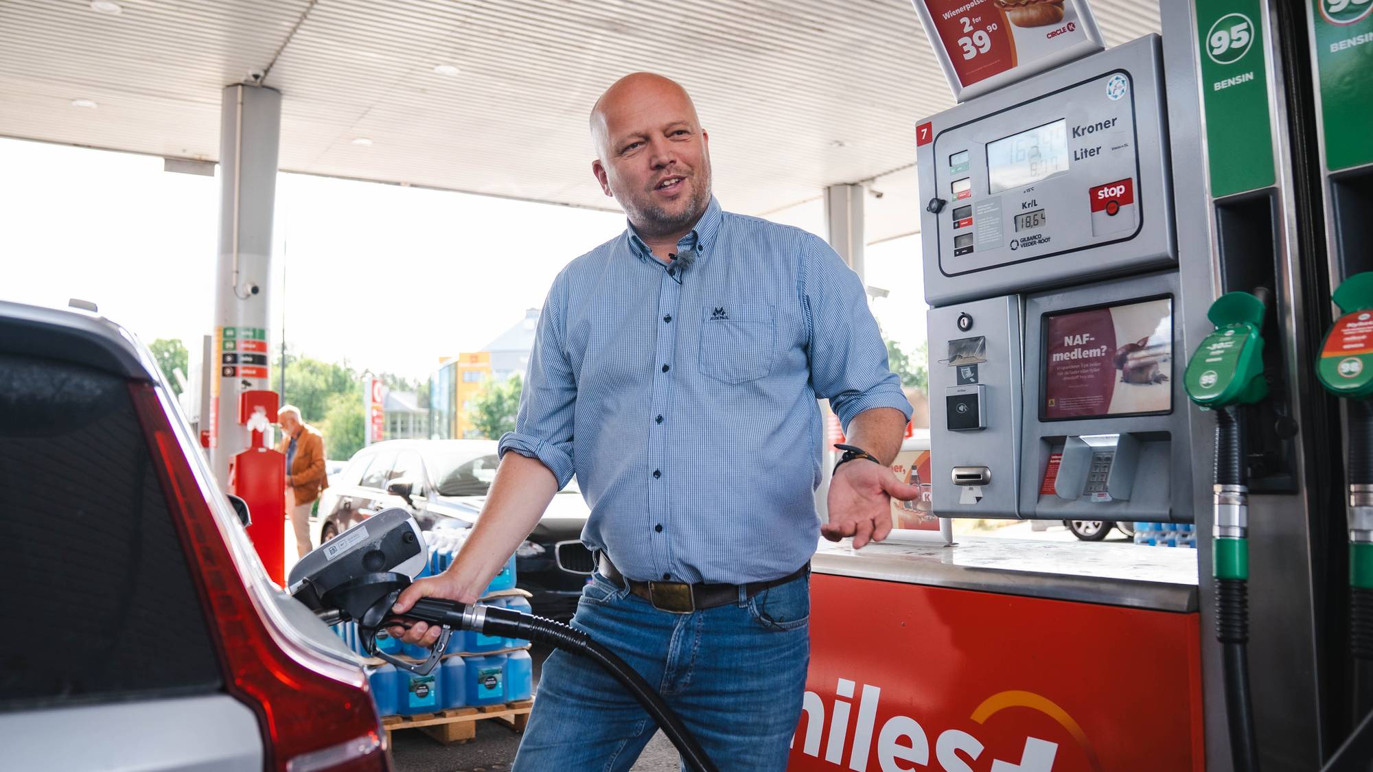 Trygve Slagsvold Vedum fyller bensin på bil ved en bensinstasjon. 