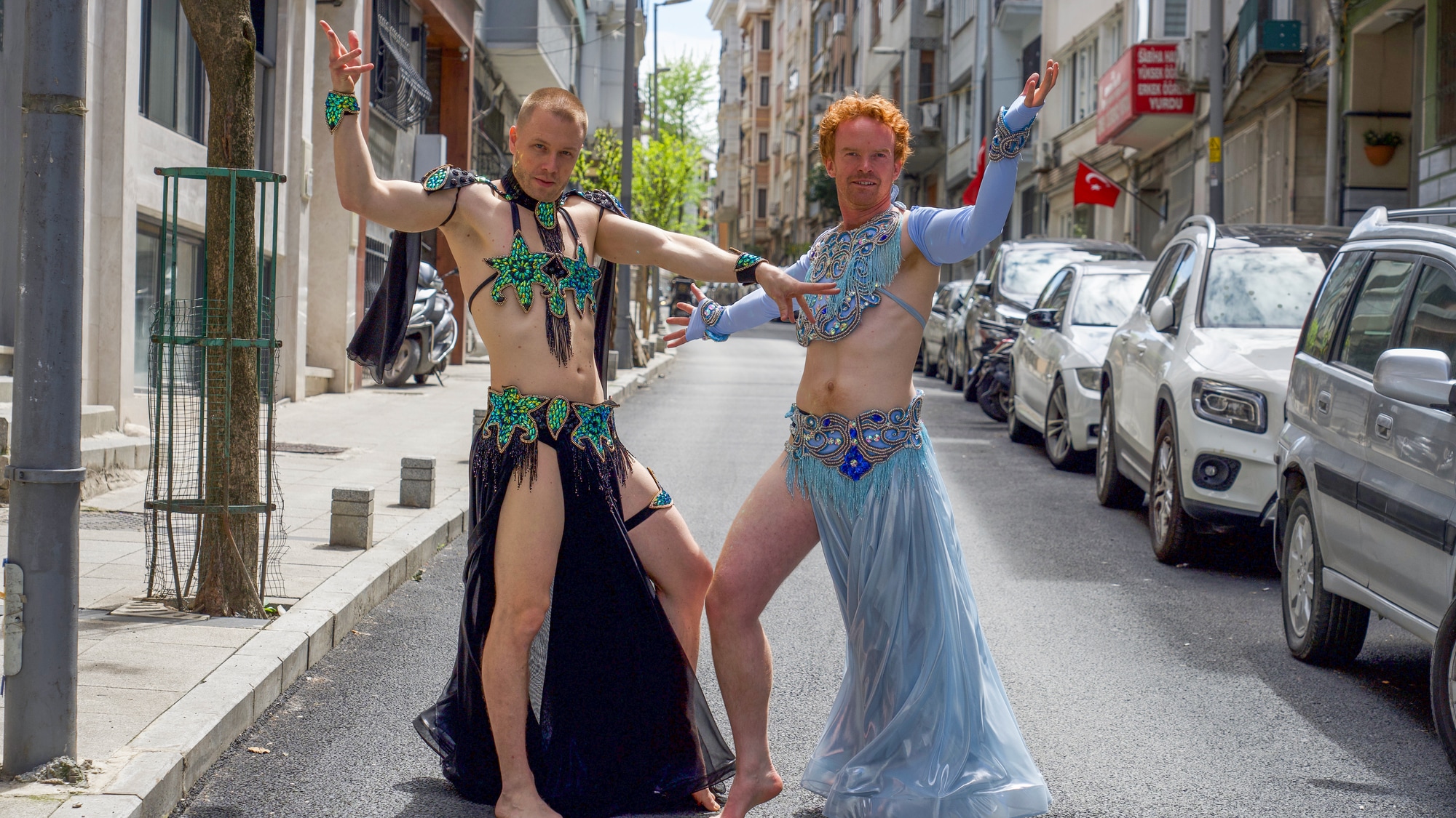 Herman og Mikkel er kledd i tradisjonelle orientalisk-inspirerte drakter med frynser og perler. De står midt i en gate. 