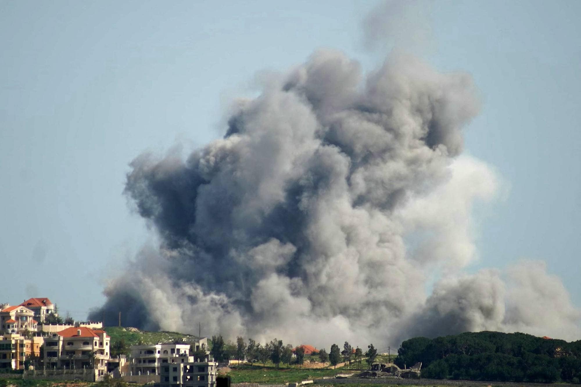 Enorme grå røykskyer på himmelen, i forgrunnen noen boligblokker