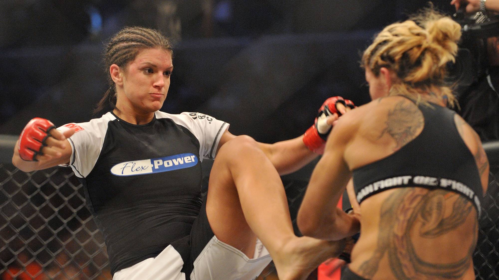 Cris Cyborg (med ryggen til ) mot Gina Carano 