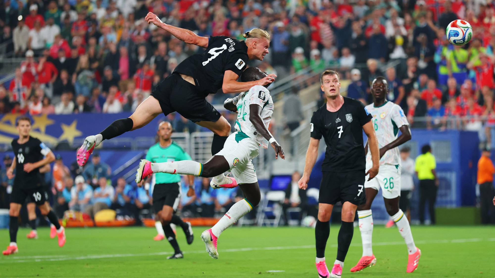 Erling Braut Haaland i en duell i luften mot en senegalesisk spiller under en fotballkamp. (Bildebeskrivelsen er laget av en KI-tjeneste)