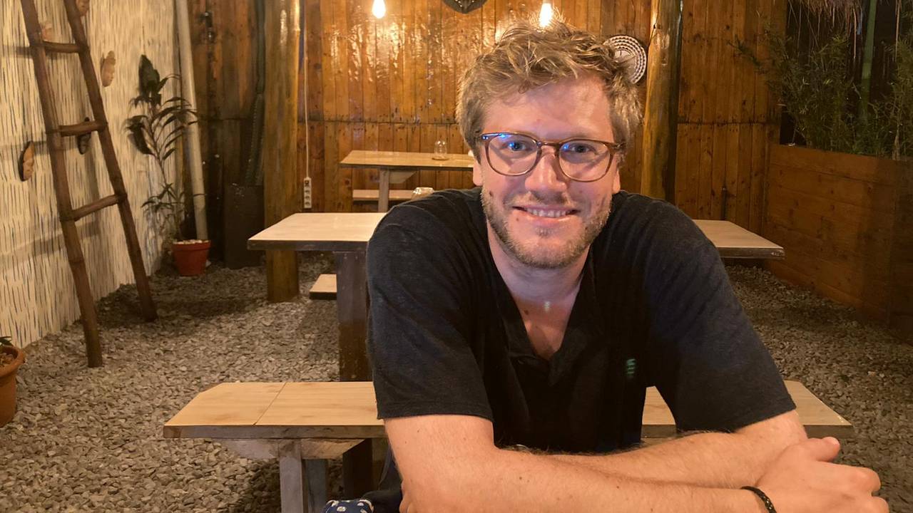 Ein mann med briller ser inn i kamera og smiler