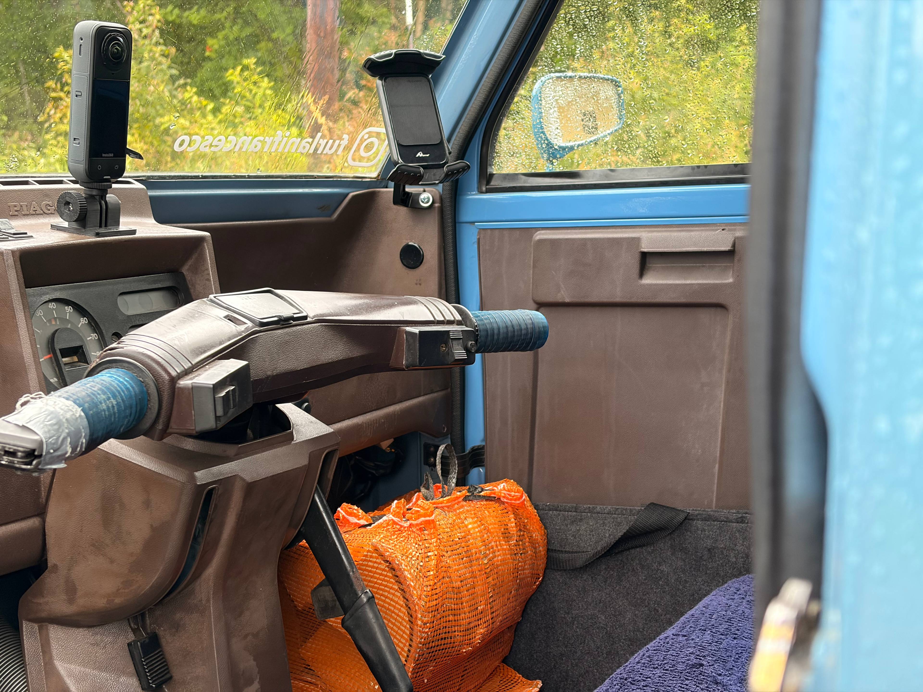 Et mopedratt og en pose med ved i fronten av mopedvarebilen fra italia