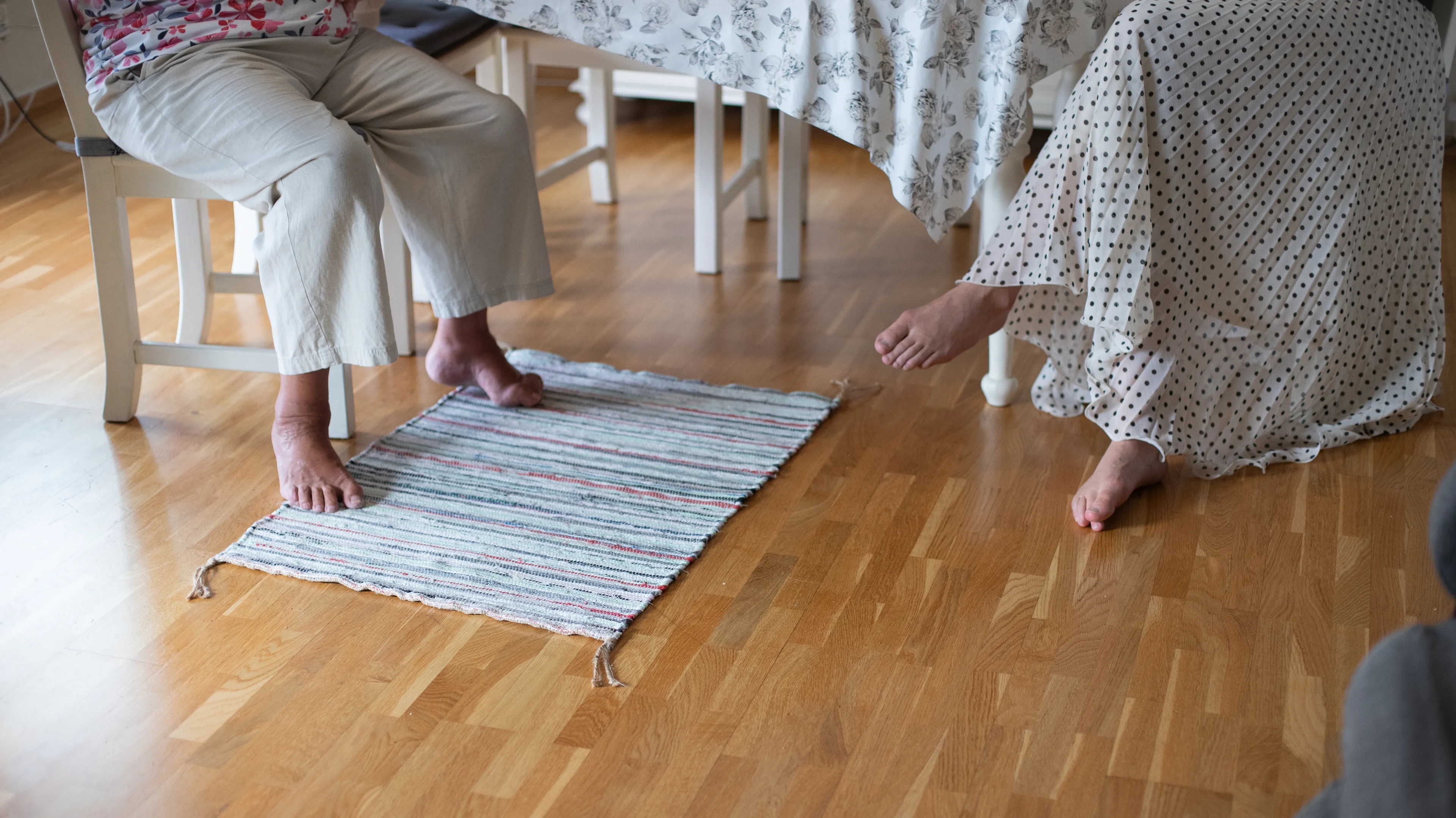 to personer som sitter med bare føtter innendørs, en av dem har en skade på en fot