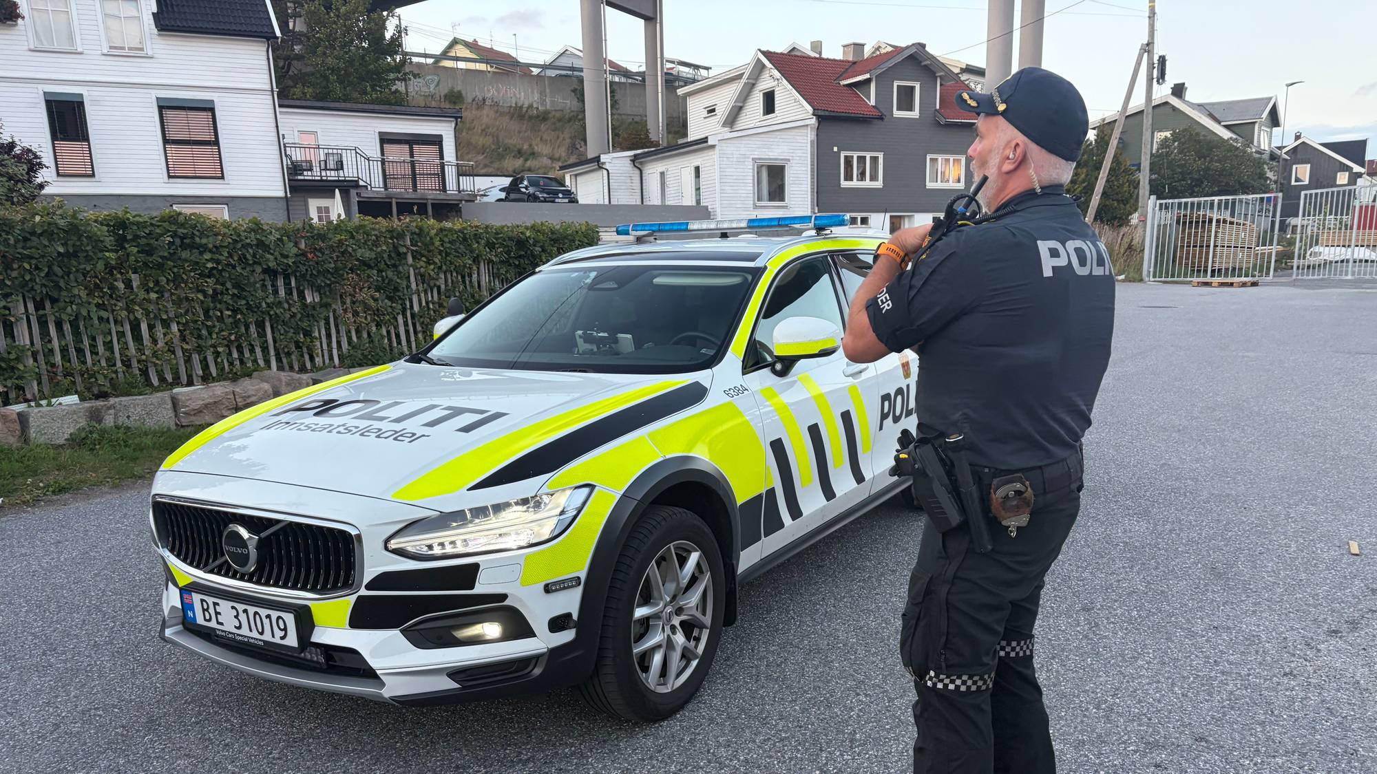 En politibil og en betjent i en gate