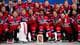 Claudio Thoma / Keystone,NTB Norges ishockeylag feirer seier med medaljer rundt halsen. Spillerne er kledd i røde drakter med teksten "NORGE". I forgrunnen står en keeper med utstyr. En pokal er plassert foran laget. (Bildebeskrivelsen er laget av en KI-tjeneste)