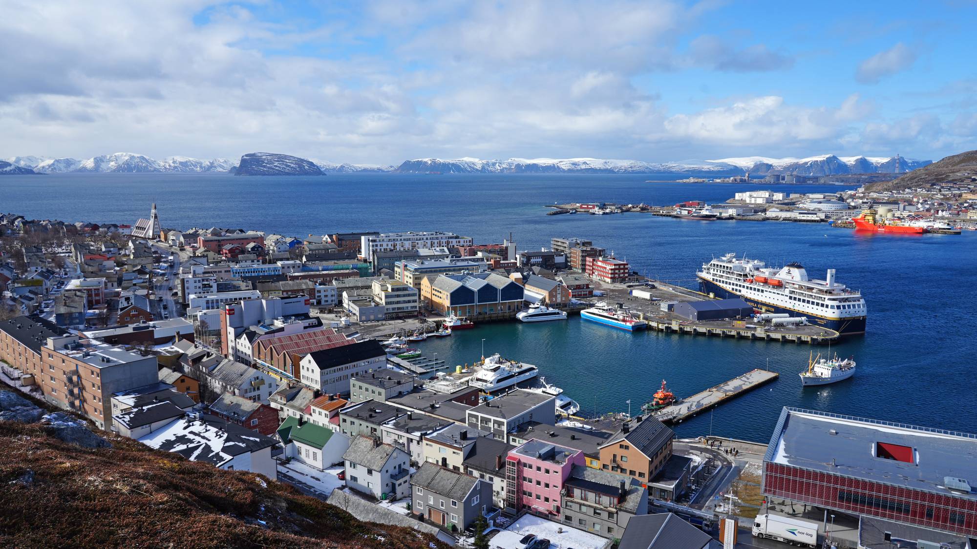 Hammerfest sentrum. Bildet er tatt 24. april 2026. På bildet ser vi blant annet Havila Kystrutens skip "Pollux", samt flere hurtigbåter ved kai. Fartøyet M/S Mårøy er vei mot kai i byens sentrum.