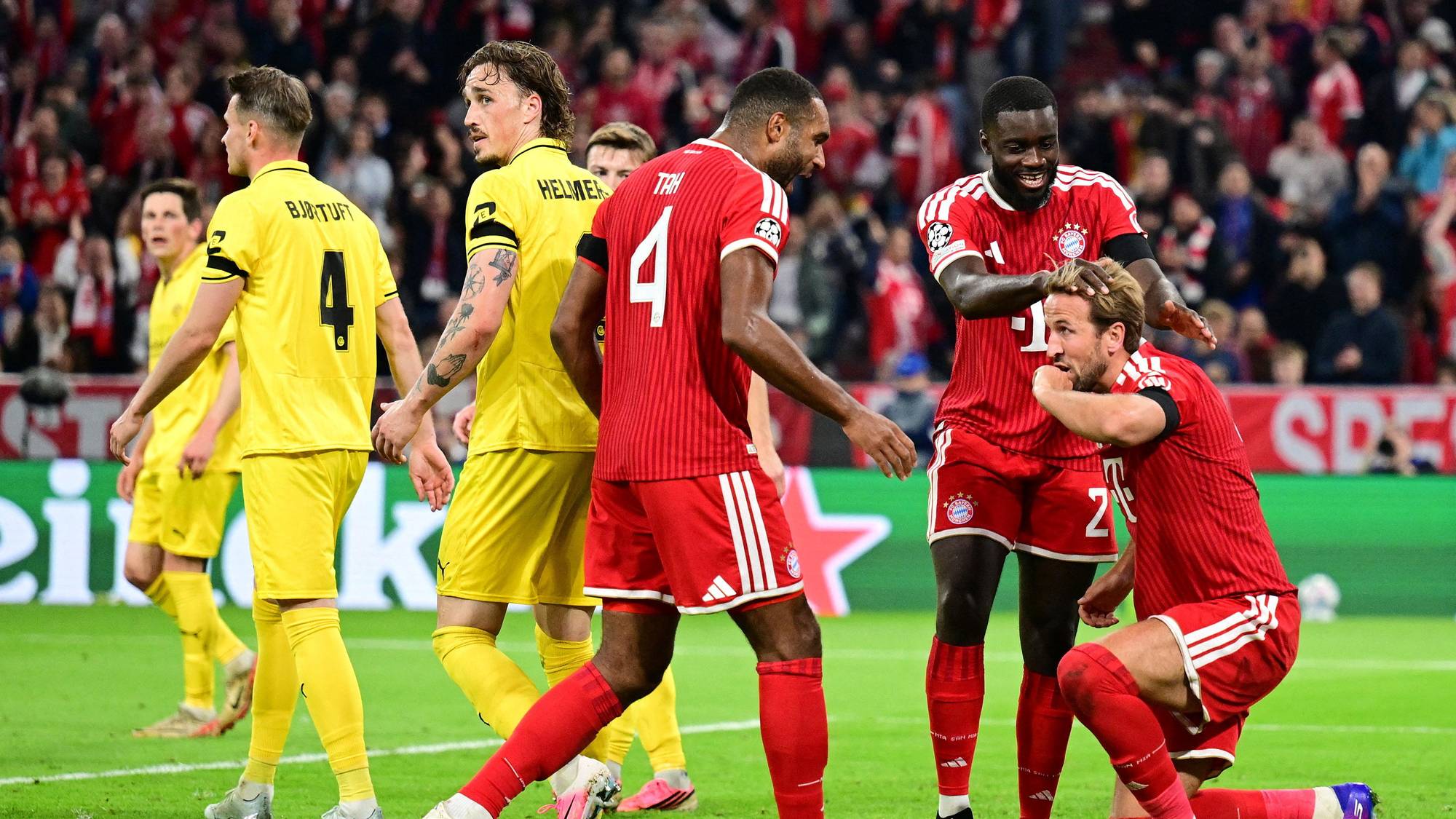 Fotballspillere fra Bayern München feirer mål foran spillere i gule drakter på en fotballbane. (Bildebeskrivelsen er laget av en KI-tjeneste)