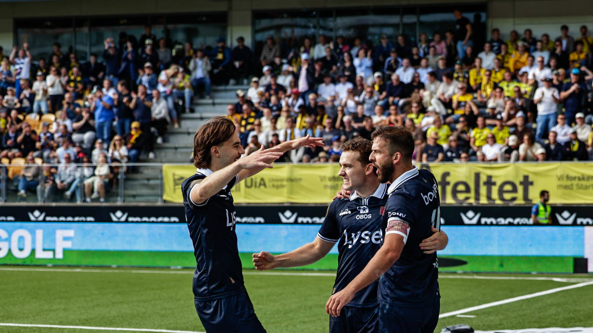 spillere i blå drakt som feirer