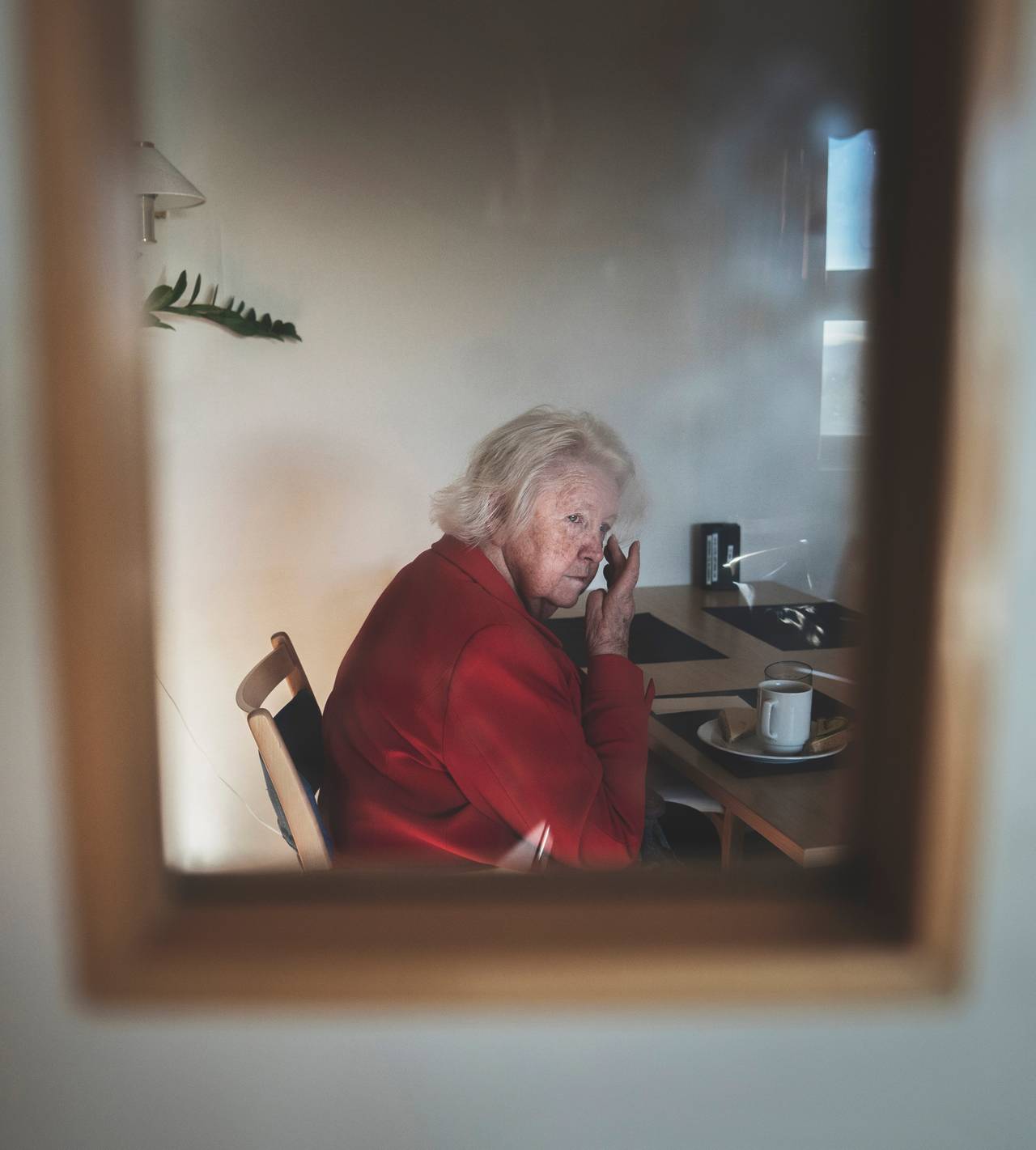 Anne Marie sitter ved frokostbordet og stirrer ut i rommet mens hånden strekkes opp til øynene.