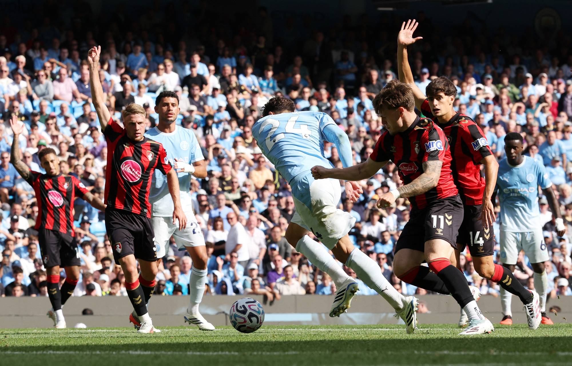 Fotballspillere fra Manchester City og Bournemouth i duell om ballen på en fullsatt stadion. (Bildebeskrivelsen er laget av en KI-tjeneste)