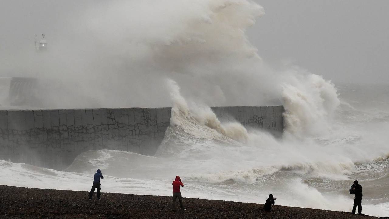 People view large waves caused by Storm Ciara as they hit the the seafront and wall in Newhaven
