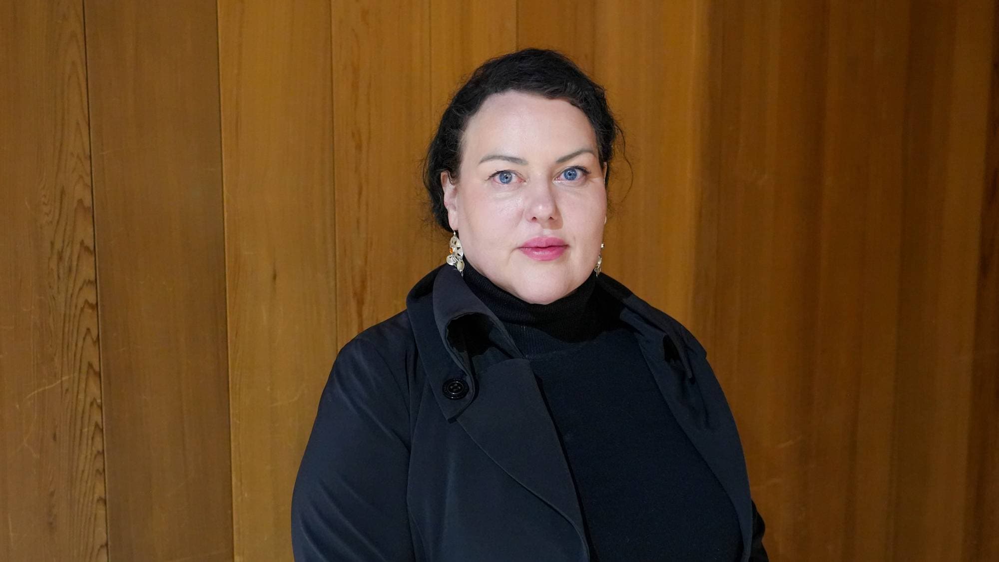 En dame i svarte klær som ser inn i kamera.
