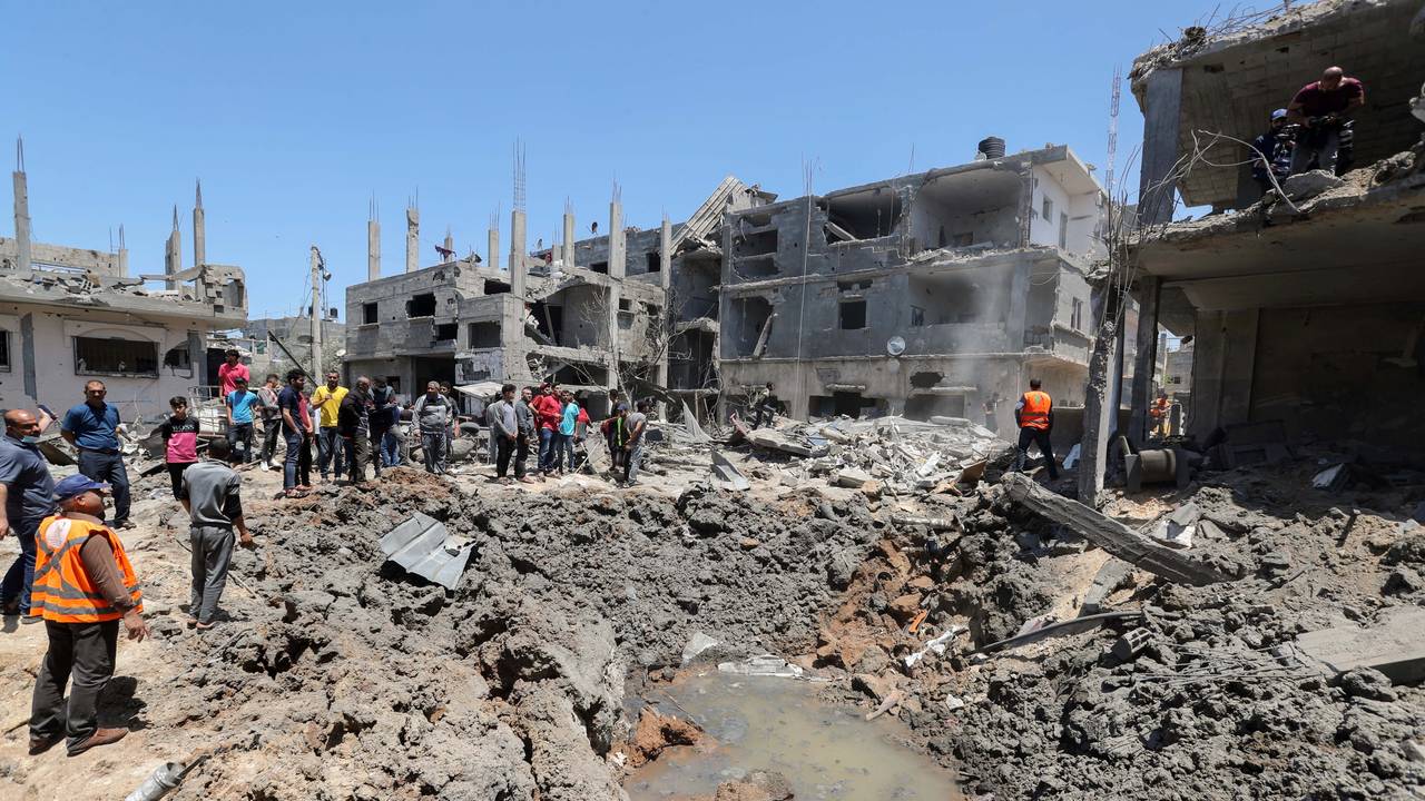 Innbyggere og redningspersonell i Gaza ser på restene av en utbombet bygning fredag 14. mai.