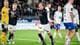 Carina Johansen / NTB En fotballspiller i mørkeblå drakt jubler med armene hevet på en gressbane. Andre spillere i henholdsvis mørkeblå og hvit drakt ser på. En keeper i gul drakt står til venstre. (Bildebeskrivelsen er laget av en KI-tjeneste)