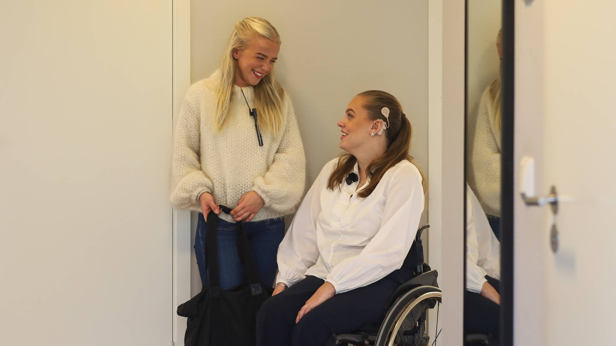 Regine Elvevold og Nora Vang ser på hverandre og smiler. 