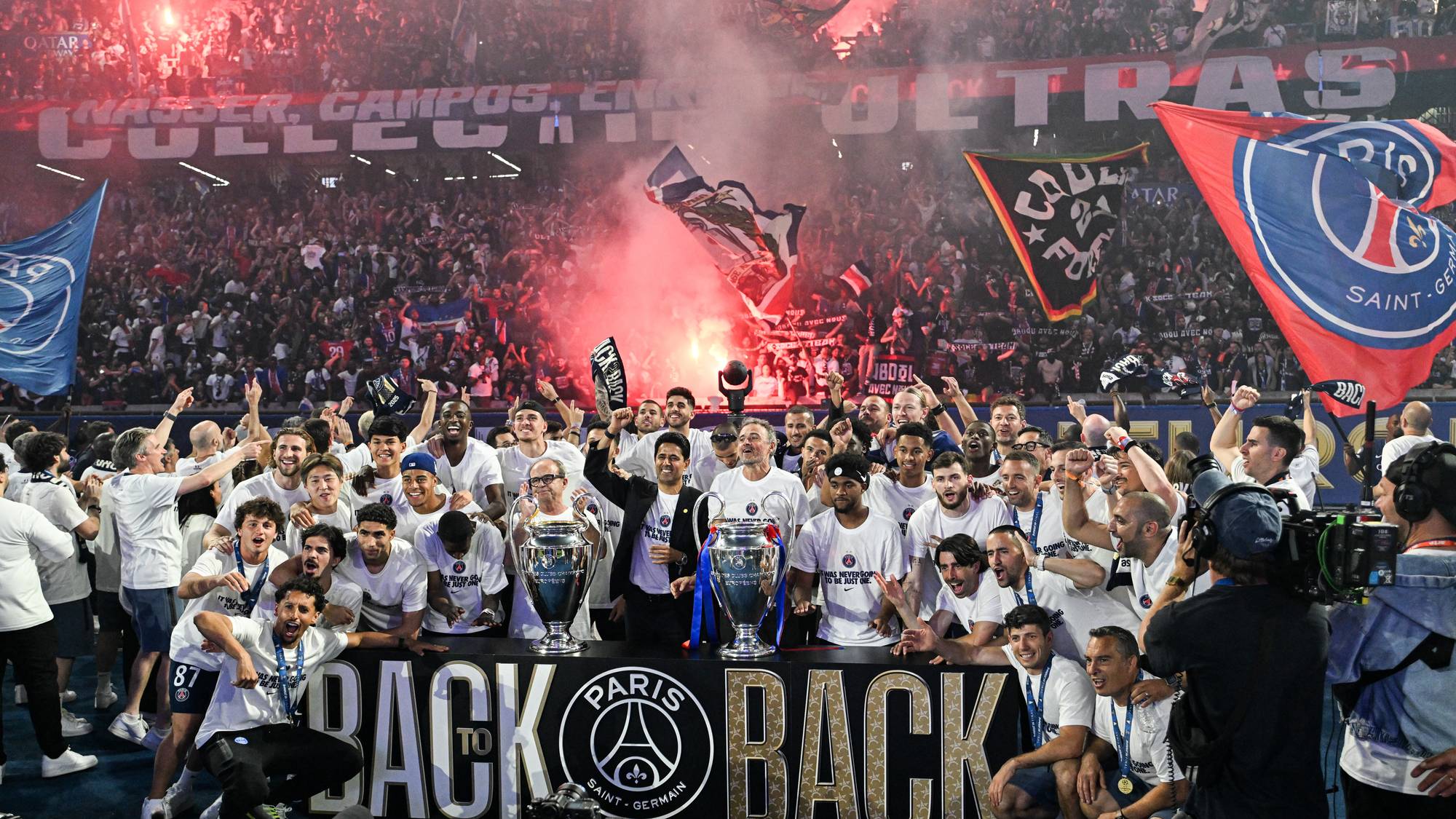 PSG-spillere feirer seriegullet med troféer på banen foran fansen som bruker røykbomber og flagg. (Bildebeskrivelsen er laget av en KI-tjeneste)