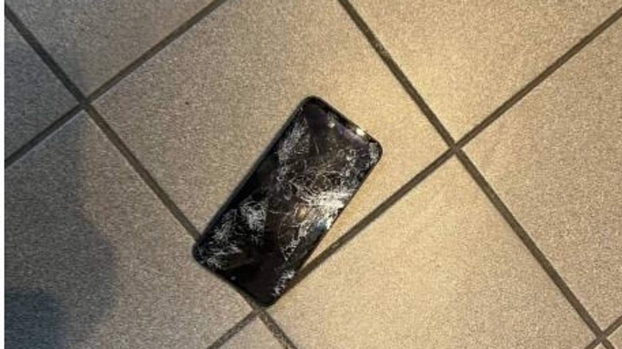 viser en telefon som er knust på bakken