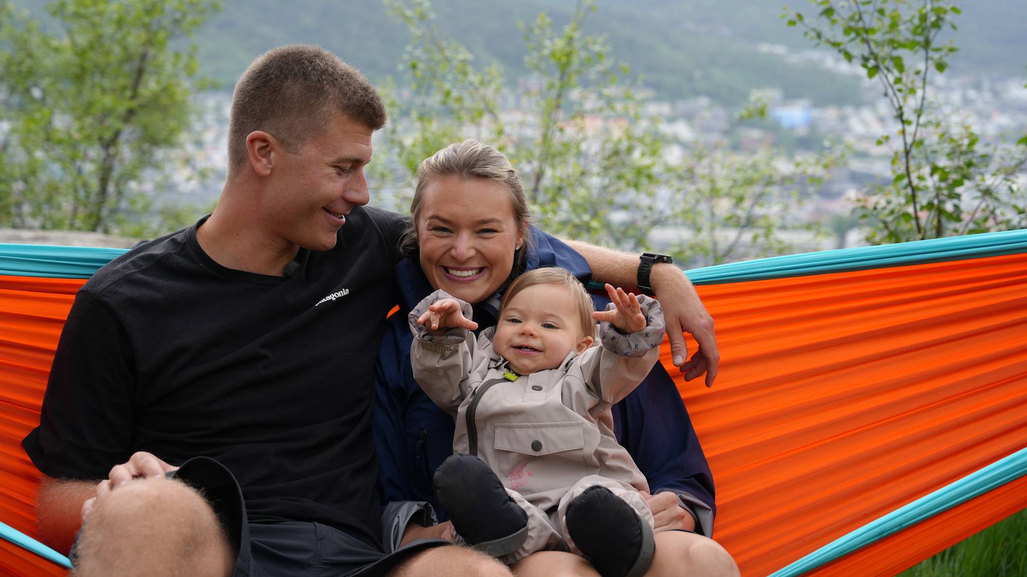 Foreldre og baby i hengekøye. 