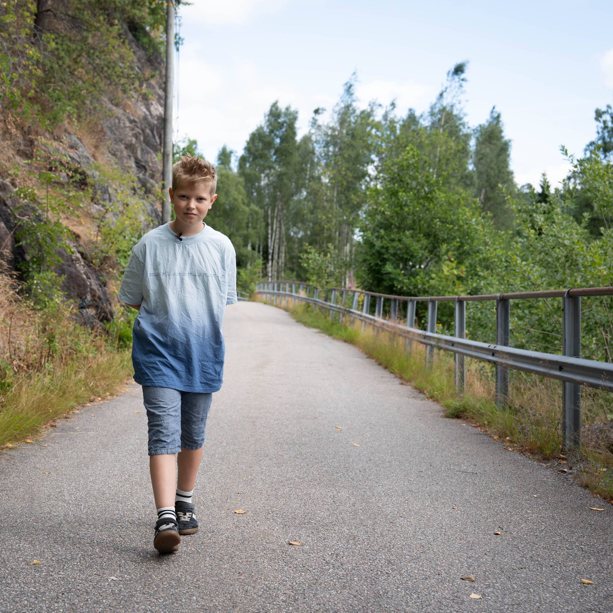 en gutt som går på en vei (Bildebeskrivelsen er laget av en KI-tjeneste)