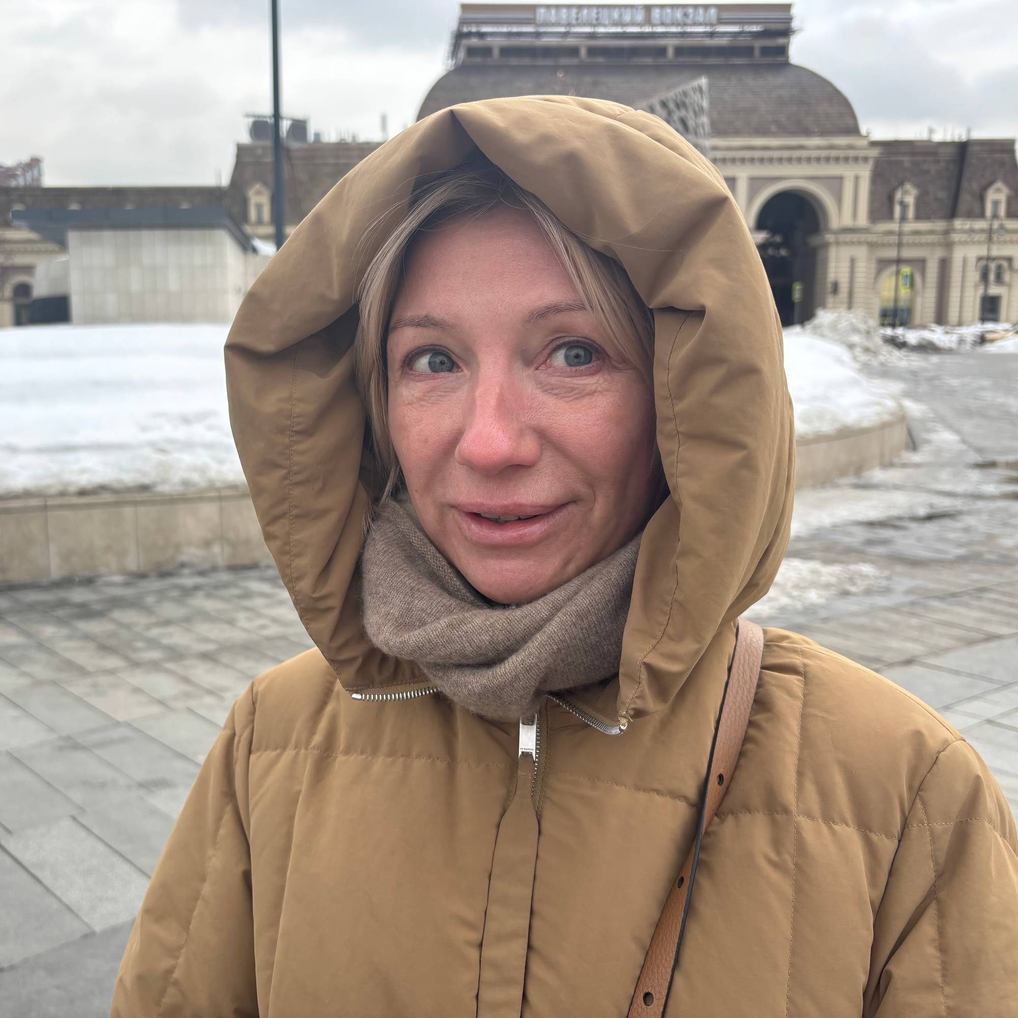 Russisk dame i brun jakke med hette ute