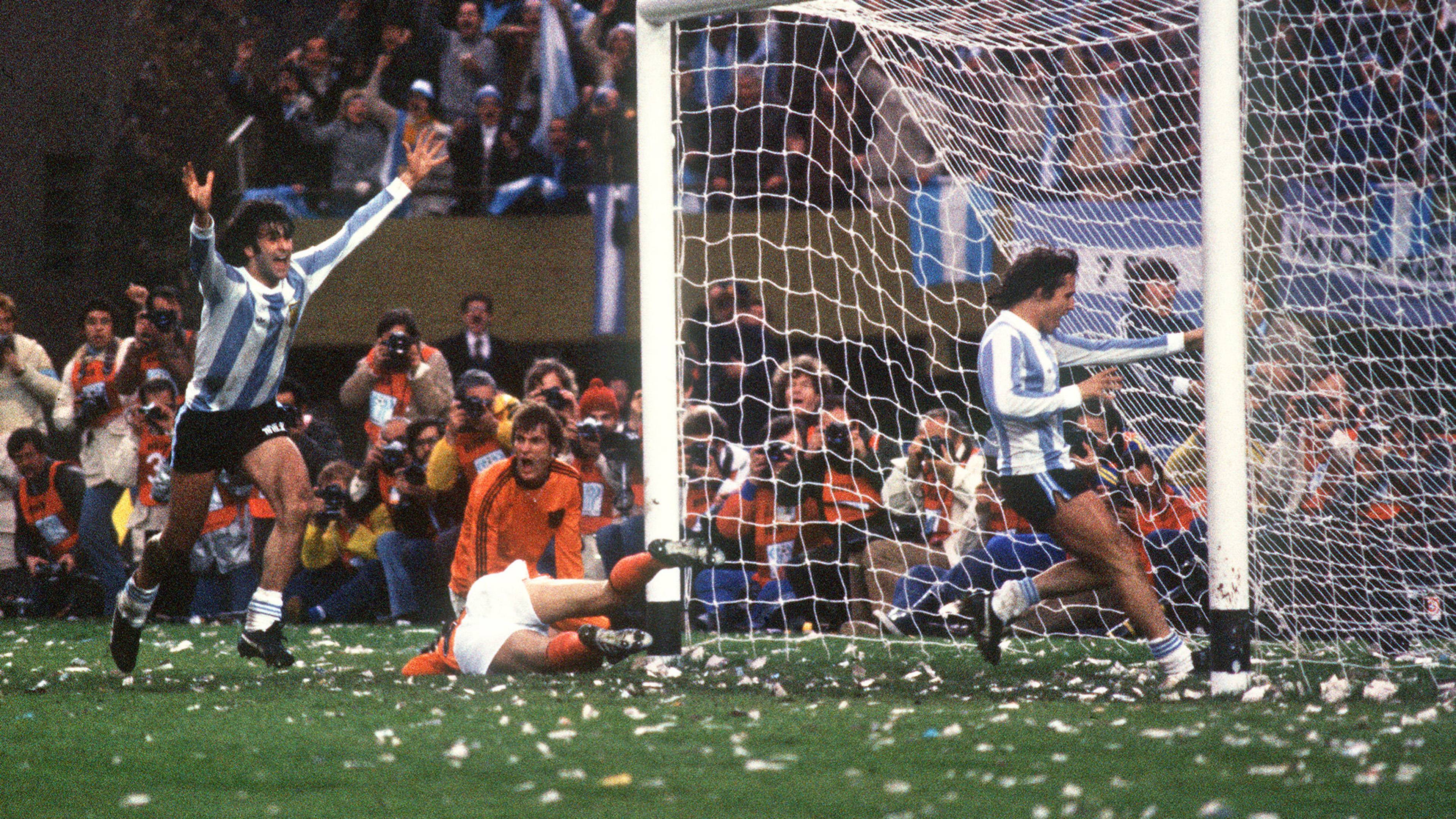 Spiller fra Argentina jubler etter scoring foran mål og en liggende nederlandsk keeper. (Bildebeskrivelsen er laget av en KI-tjeneste)