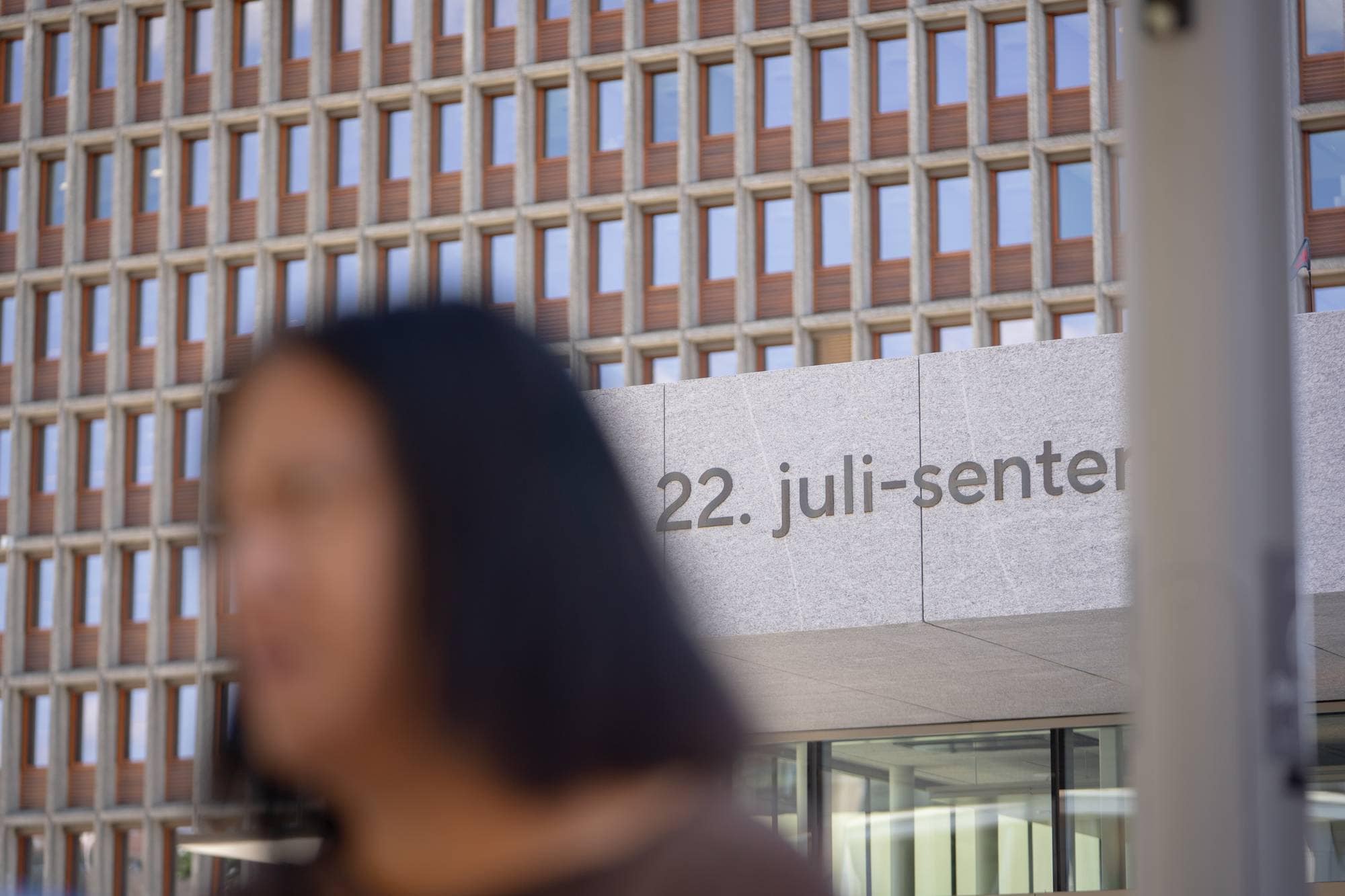22. juli-senteret med en person ute av fokus i forgrunnen. (Bildebeskrivelsen er laget av en KI-tjeneste)