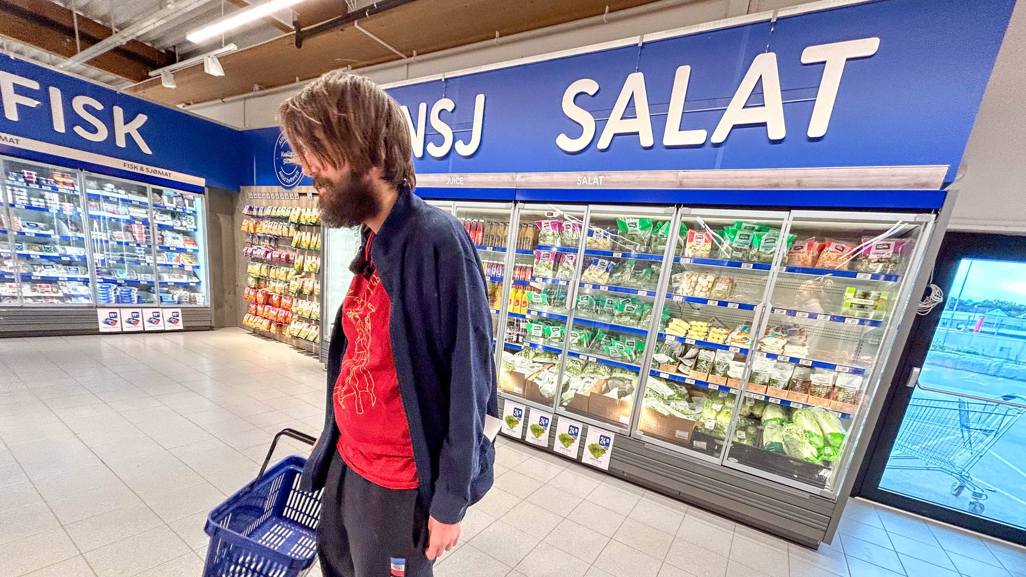 en person med en kurv som går i en butikk